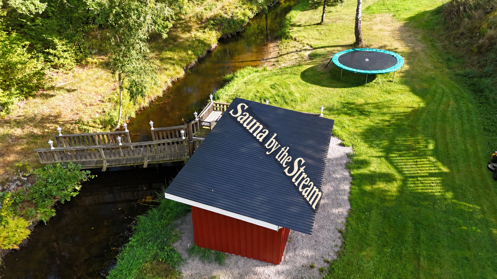 Unsere Sauna am Bach aus der Luft mit der Aufschrift Sauna by the Stream